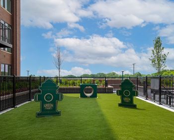 a grassy area with two green fire hydrants in front of a building